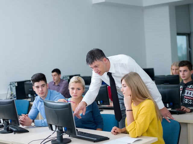 students with teacher  in computer lab classrom